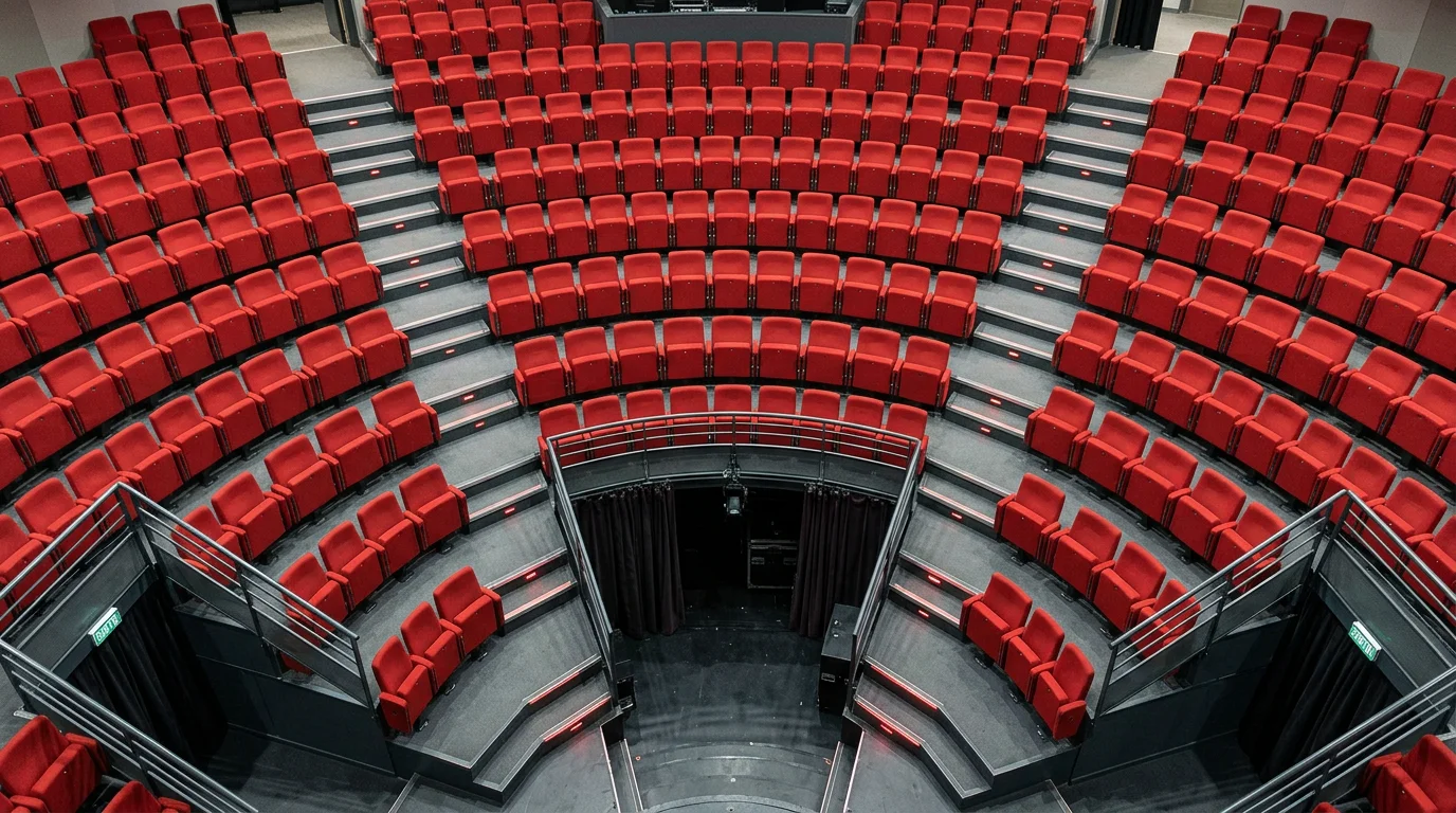 Vue en plongée de fauteuils rouges en gradins dans un hémicycle