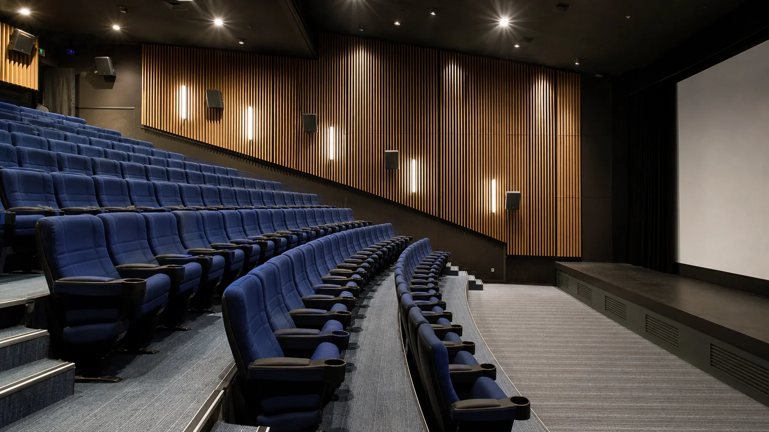 Vue latérale d’un amphithéâtre avec fauteuils bleu nuit face à une scène