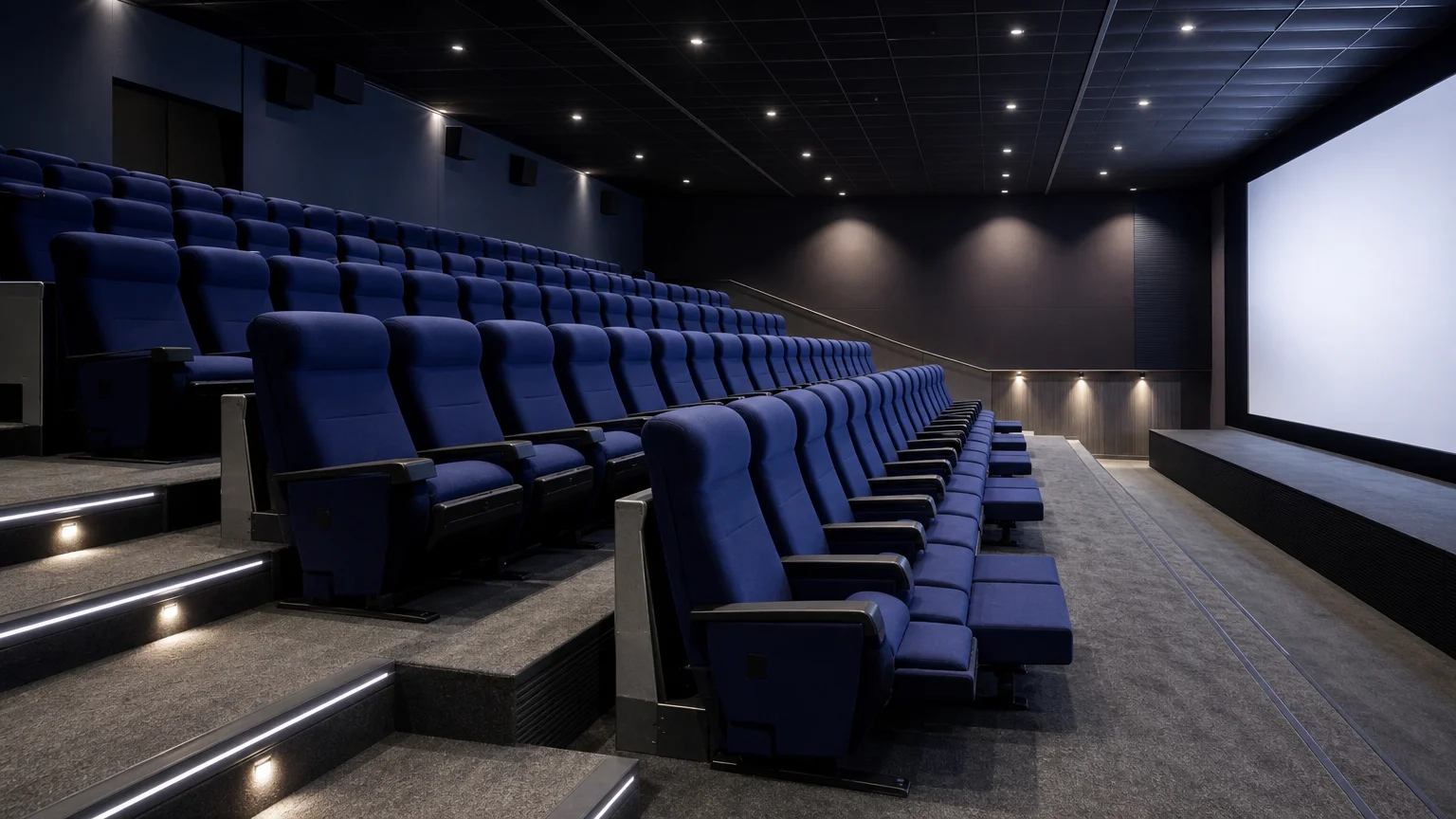 Vue latérale de fauteuils cinéma inclinés bleu nuit dans un auditorium