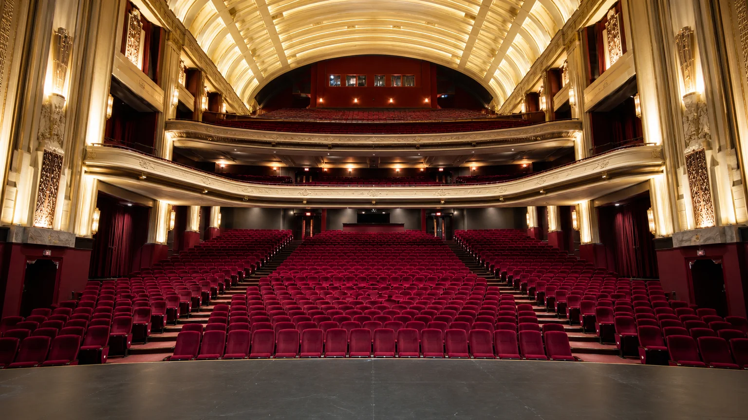 Grande salle de cinéma art déco aux fauteuils bordeaux vue depuis la scène