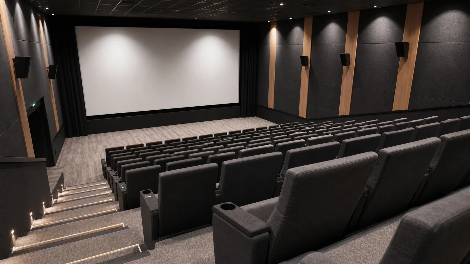 Vue en plongée de fauteuils de cinéma gris et noirs dans une salle moderne