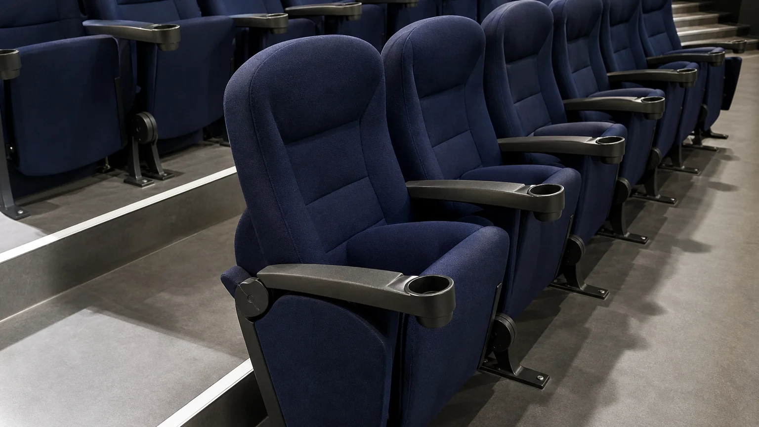 Vue latérale de fauteuils de cinéma bleu nuit dans une salle lumineuse